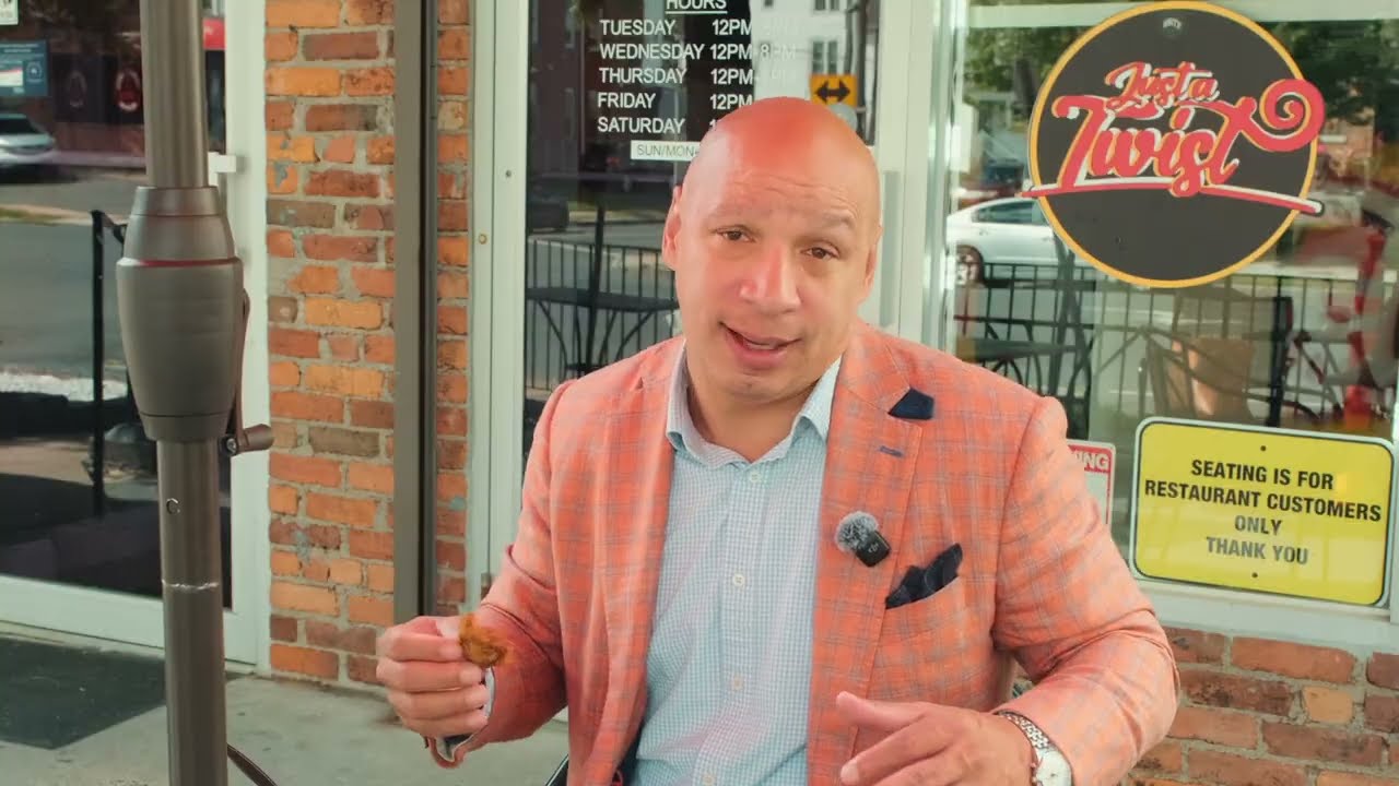 Lawyer A. Twillie II tasting food outside Just A Twist restaurant in Hartford, Connecticut, during Lunch With Lawyer Episode 1